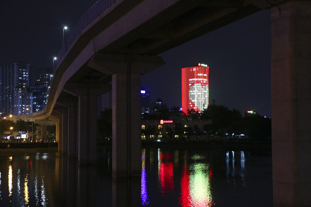 Một tòa nhà khác cạnh đó cũng nhuộm đỏ màu cờ cùng trái tim ở giữa, phía trên là dòng chữ chạy Tiến lên Việt Nam.