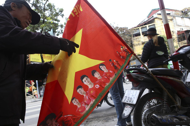 Chiếc xe máy được buộc lá cờ đỏ sao vàng in hình các thành viên đội bóng và dòng chữ Việt Nam vô địch.